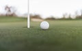 Golf ball close to cup hole on putting green Royalty Free Stock Photo