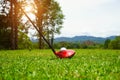 Golf ball and golf club in beautiful golf course at Thailand. Collection of golf equipment resting on green grass with green Royalty Free Stock Photo