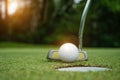 Golf ball and golf club in beautiful golf course at Thailand. Collection of golf equipment resting on green grass with green Royalty Free Stock Photo