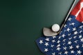 Golf ball and golf club with flag of USA on green table background, sport concept Royalty Free Stock Photo