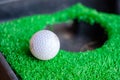 Golf ball edge hole cup on lawn Royalty Free Stock Photo