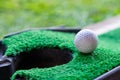 Golf ball edge hole cup on lawn Royalty Free Stock Photo