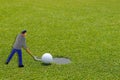 Golf ball at the edge of putting cup with a help from miniature Royalty Free Stock Photo