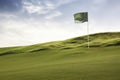 Golf ball and a flag on green hill Royalty Free Stock Photo
