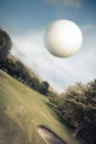 Golf ball flying over a green field Royalty Free Stock Photo