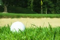 Golf ball in front of bunker