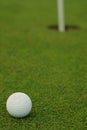 Golf ball in front of the hole Royalty Free Stock Photo