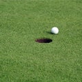 Golf ball in front of the hole Royalty Free Stock Photo