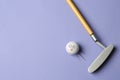 Golf ball with funny face flying away from club on lilac background - creative image