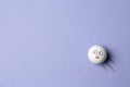 Golf ball with funny face flying on lilac background - creative image Royalty Free Stock Photo
