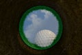 Golf ball going into a hole view from inside the pit hole