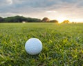 Golf ball on grass in the foreground and beautiful golf green at the background Royalty Free Stock Photo