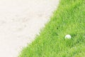 Golf ball on green grass near sand bunker Royalty Free Stock Photo