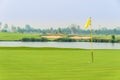 Golf ball on green near hole with yellow flag Royalty Free Stock Photo