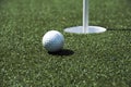 Golf ball and hole on a field Royalty Free Stock Photo