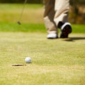 Golf, ball and hole on a green in summer for sports, recreation or leisure closeup for hobby. Grass, ground or field Royalty Free Stock Photo