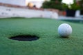 Golf ball and hole in a minigolf field Royalty Free Stock Photo