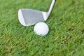 Golf ball and iron on green grass detail macro Royalty Free Stock Photo