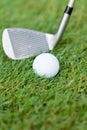 Golf ball and iron on green grass detail macro