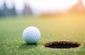 Golf ball lies near targeted hole on field waiting for putt