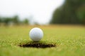 Golf ball on lip of cup close up, Golf ball on the lawn Royalty Free Stock Photo