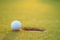 Golf ball on lip of cup in course Royalty Free Stock Photo