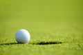 Golf ball near hole Royalty Free Stock Photo