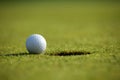 Golf ball near hole Royalty Free Stock Photo