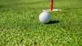 Golf ball near hole with flag Royalty Free Stock Photo