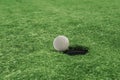 Golf ball near the hole in a grass field Royalty Free Stock Photo