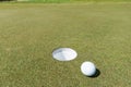 Golf ball near the hole Royalty Free Stock Photo