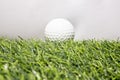 The golf ball is placed on a green artificial grass. It means getting ready to play golf Royalty Free Stock Photo