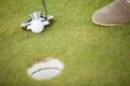 Golf ball, putter and boy's legs on green Royalty Free Stock Photo