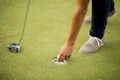 Golf ball, putter and boy's legs on green Royalty Free Stock Photo