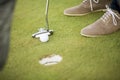 Golf ball, putter and boy's legs on green Royalty Free Stock Photo