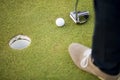 Golf ball, putter and boy's legs on green Royalty Free Stock Photo