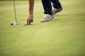 Golf ball, putter and boy's legs on green Royalty Free Stock Photo