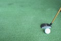 Golf ball and putter on green grass Royalty Free Stock Photo