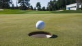 Golf ball rolling into the hole at the edge of the cup Royalty Free Stock Photo