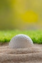 Golf ball in sand bunker near the lawn Royalty Free Stock Photo