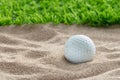 Golf ball in sand bunker near the lawn Royalty Free Stock Photo