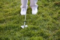 Golf ball, shoes and driver in the grass