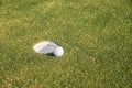 Golf ball sits at the lip of the hole on the putting green. Royalty Free Stock Photo