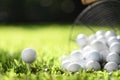 Golf ball on tee and golf balls in basket on green grass for practice Royalty Free Stock Photo