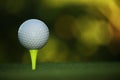 Golf ball on tee in beautiful golf course at sunset Royalty Free Stock Photo