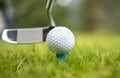 Golf ball on tee in front of driver Royalty Free Stock Photo