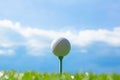 Golf ball on tee on golf course on hills and blue sky Royalty Free Stock Photo