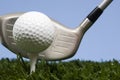 Golf ball on tee on grass with driver Royalty Free Stock Photo