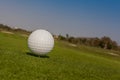 Golf ball on tee off zone with golf course background. Royalty Free Stock Photo