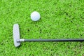 Golf ball on a tee and putter in green grass course Royalty Free Stock Photo